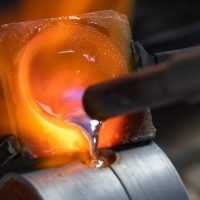 Molten silver being poured into a casting flask