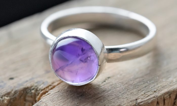 Cabochon stone setting with a amethyst stone on a jewellery bench peg