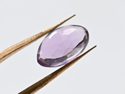 freeform amethyst slice held by brass tweezers on our stone setting course